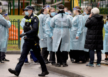 Dozens of workers put on their PPE before heading into locked down towers. Picture: Andrew Henshaw