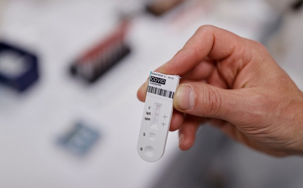 A member of a laboratory staff displays a positive coronavirus test at the Barrand medical laboratory in Colmar, as the spread of the coronavirus disease (COVID-19) continues in France, April 16, 2020. REUTERS/Christian Hartmann - RC2S5G9R2QA7