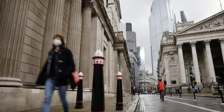 A pedestrian wearing a mask because of the coronavirus pandemic walks past the Bank of England in the City of London on December 11, 2020. - A Brexit trade deal between Britain and the European Union looked to be hanging in the balance on Friday, after leaders on both sides of the Channel gave a gloomy assessment of progress in last-gasp talks. The Bank of England said Friday that UK banks remained "resilient" to the risks of Brexit and coronavirus, but warned financial services could face "disruption" when the transition period ends. (Photo by Tolga Akmen / AFP)