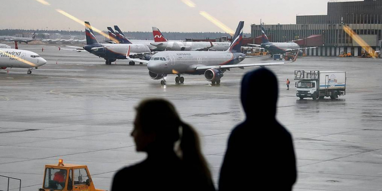 MOSCOW REGION, RUSSIA - MARCH 1, 2020: Travellers look at aircraft from a waiting area at the Sheremetyevo International Airport. On 1 March 2020, Russia suspended all direct flights from South Korea except direct flights operated by Aeroflot and Korean Air and charter flight services by three more Russian air carriers in connection with an outbreak of the novel coronavirus in East Asia. The remaining flights between Russia and South Korea will be restricted to the Sheremetyevo International Airport. Previously, Russia restricted flights from China and Iran. As of 1 March, 2020, more than 86,000 people have been infected with the COVID-19 virus in the world, with more than 79,000 in the People's Republic of China and more than 3,000 in South Korea. Russia has confirmed two cases of coronavirus. Valery Sharifulin/TASSÐîññèÿ. Ìîñêîâñêàÿ îáëàñòü. Ïàññàæèðû â àýðîïîðòó Øåðåìåòüåâî. Ðîññèÿ îãðàíè÷èëà àâèàñîîáùåíèå ñ Þæíîé Êîðååé èç-çà ðàñïðîñòðàíåíèÿ â ýòîé ñòðàíå êîðîíàâèðóñà íîâîãî òèïà. Ñ 1 ìàðòà ïîëåòû ìåæäó ñòðàíàìè áóäåò âûïîëíÿòü òîëüêî "Àýðîôëîò" è Korean Air. Òàêîå ðåøåíèå áûëî ïðèíÿòî îïåðàòèâíûì øòàáîì ïî áîðüáå ñ ðàñïðîñòðàíåíèåì êîðîíàâèðóñà. Âàëåðèé Øàðèôóëèí/ÒÀÑÑ
