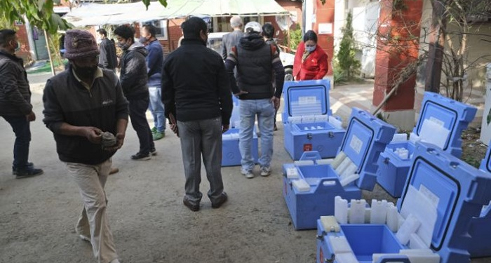 Health workers and officers stand by empty vaccine storage cold boxes that will be filled with COVID-19 vaccines to be transported to various districts of the state, in Imphal, in the northeastern Indian state of Manipur, Thursday, Jan. 14, 2021. India started inoculating health workers Saturday, Jan. 16 in what is likely the world's largest COVID-19 vaccination campaign, joining the ranks of wealthier nations where the effort is already well underway. (AP Photo/Yirmiyan Arthur)