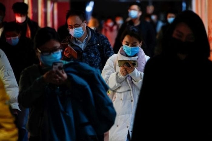 FILE PHOTO: People wearing face masks use their cellphones at a subway station following the coronavirus disease (COVID-19) outbreak, in Shanghai, China January 25, 2021. REUTERS/Aly Song
