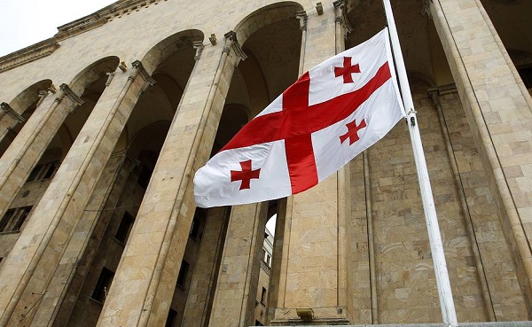 The Georgian national flag flies at half-mast in front of the parliament building during a day of mourning in Tbilisi June 7, 2013. A suicide bomber detonated a small truck loaded with explosives in southern Afghanistan, killing seven Georgian soldiers, NATO and Georgian officials said on Friday, and the Afghan Taliban claimed responsibility. REUTERS/David Mdzinarishvili (GEORGIA - Tags: MILITARY CONFLICT POLITICS)